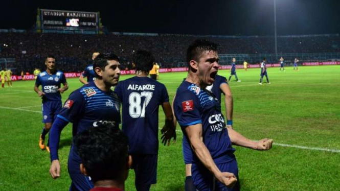 Striker Arema Gustavo Giron merayakan gol.