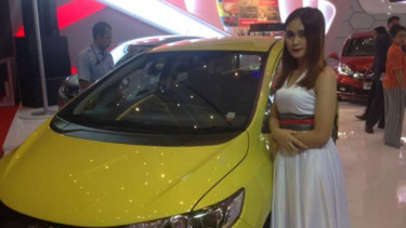 Andari saat berpose di depan mobil yang dijaganya.