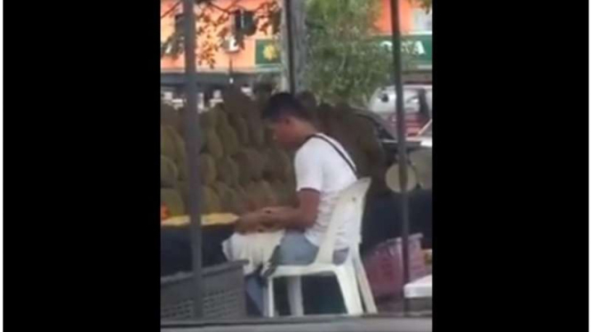 Pedagang durian di Malaysia meludahi buah durian yang telah dibuka sebelum dijual ke calon pembelinya, Kamis (19/5/2016)