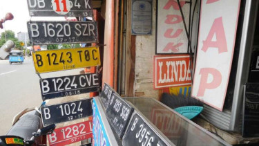 Bisnis pembuatan pelat nomor di pinggir jalan.