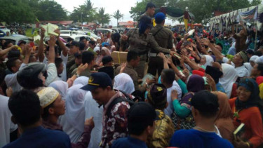 Warga Kabupaten Pesisir Barat, Lampung, berebut puluhan ribu Alquran yang dibagikan Pemerintah Kabupaten untuk menyambut Ramadan pada Jumat, 3 Juni 2016.