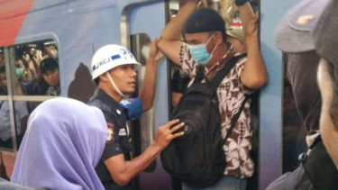Penumpang berebut masuk ke KRL di Stasiun Cawang, Jakarta Timur.