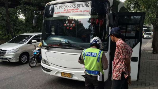 Polisi merazia bus antar kota yang menerobos busway di Jalan Yos Sudarso, Selasa, 14 Juni 2016.