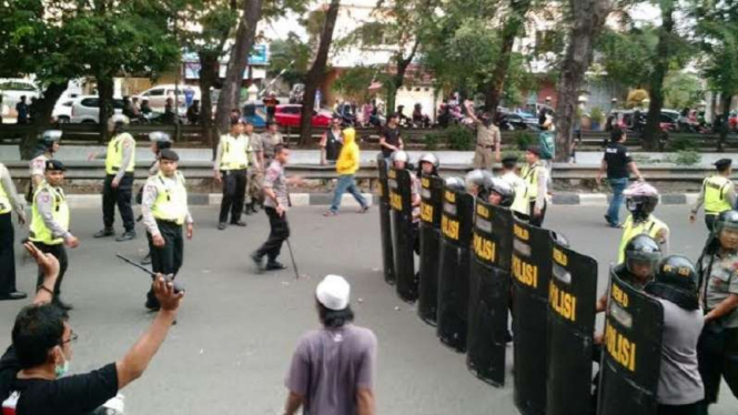 Ilustrasi polisi hadang massa yang ingin bentrok.