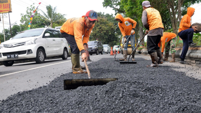  Pekerja melakukan penambalan jalan raya di ruas jalan utama jalur tengah Jawa Tengah Semarang-Secang-Purwokerto di wilayah Temanggung, Jawa Tengah, Selasa (28/6/2016). 