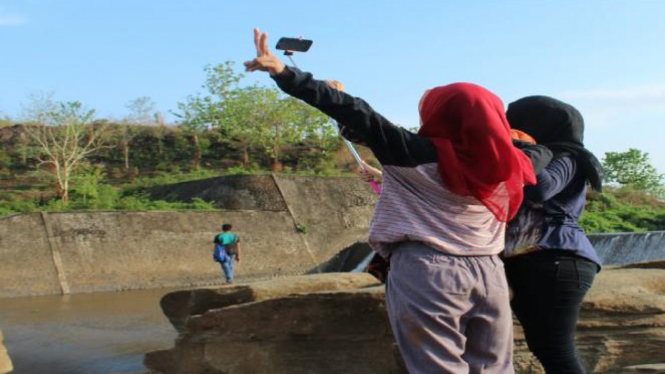 Pengunjung Bendungan Kampili sedang asik selfi sambil menunggu waktu berbuka (Dok. Pribadi)