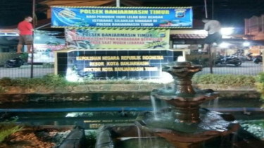 Anggota Polsekta Banjarmasin Timur memasang spanduk pelayanan istirahat & penitipan barang bagi pemudik.