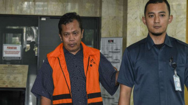 Panitera Pengganti PN Jakarta Pusat Santoso (kiri) berjalan usai menjalani pemeriksaan di Gedung KPK, Jakarta, Kamis (21/7)
