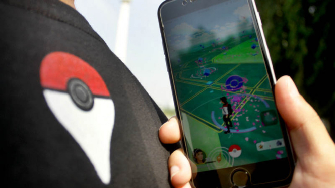 Anggota komunitas Pokemon_Go_Jakarta asyik memainkan game Pokemon Go di kawasan Monumen Nasional (Monas), Jakarta, Minggu, 24 Juli 2016.