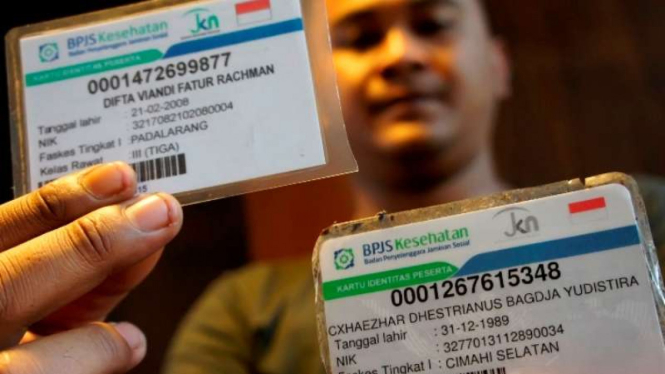 Seorang petugas perlihatkan contoh kartu BPJS Kesehatan.
