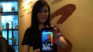 Seorang model menunjukkan ponsel Infinix terbaru.