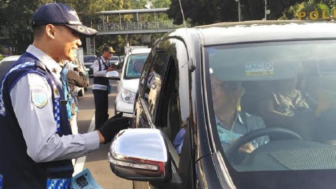 Petugas memberikan teguran kepada pelanggar ganjil genap.