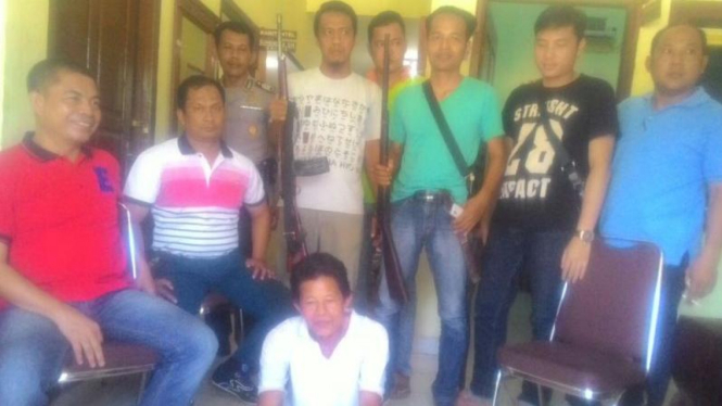 Tersangka Erwani bersama barang bukti senjata AK 47 yang ditangkap petugas Polsek Rambutan.