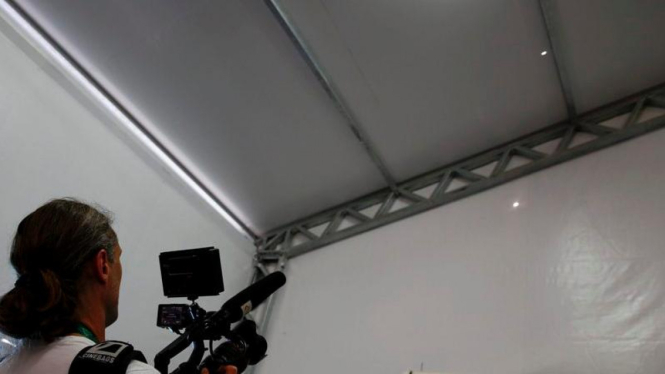 Seorang pewarta tengah merekam dua lubang di media centre venue berkuda.