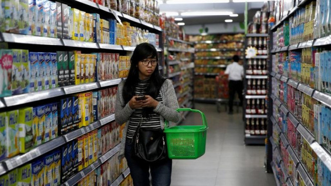 Seorang warga sedang belanja di supermarket. 