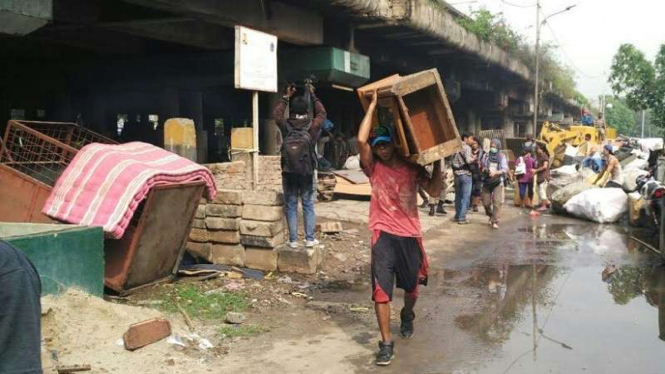 Seorang warga membawa barang miliknya.