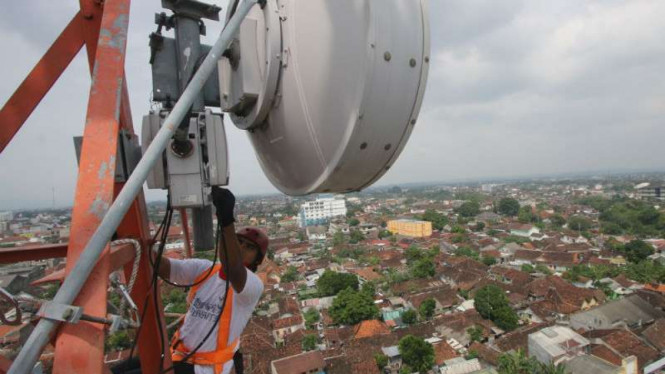 Petugas memperbaiki base transceiver station (BTS).