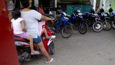 Ibu boncengi dua anaknya.