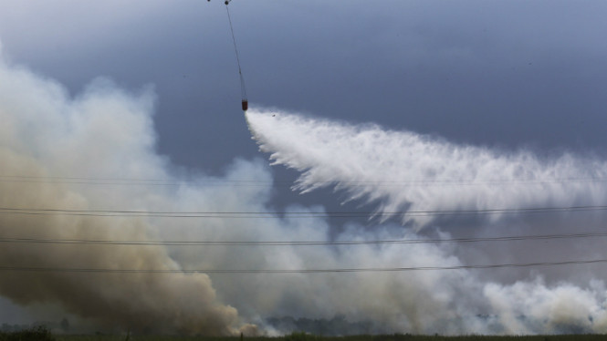 Helikopter Mi8-Mtv milik Badan Nasional Penanggulangan Bencana (BNPB) melakukan pemadaman kebakaran lahan dari udara (water boombing) di Indralaya Utara, Ogan Ilir (OI), Sumatera Selatan, Jumat (19/8).