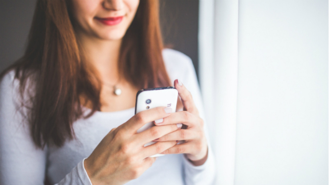 Ilustrasi wanita bermain handphone.