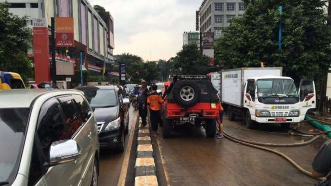 Petugas sedang  membersihkan sisa-sisa banjir di Kemang, 28 Agustus 2016.