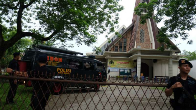 Personel Brimob berjaga di halaman Gereja Katolik Stasi Santo Yosep pascaperistiwa teror bom di lokasi tersebut, Medan, Sumatera Utara, Minggu (28/8/2016). 