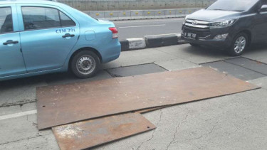Lubang besar hanya ditutup lempengan besi di Jalan Sudirman, Jakarta.