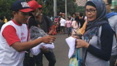 Bagi-bagi kerudung untuk mendukung Wanita Emas dalam Pilgub DKI
