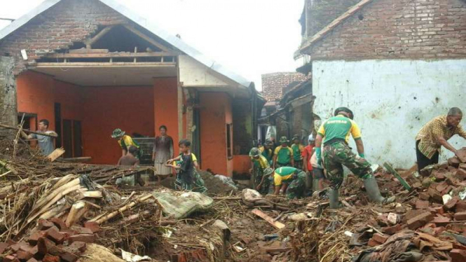 Prajurit Batalion Infanteri Raiders 303/Setia Sampai Mati membersihkan rumah warga akibat banjir bandang di Garut pada Senin, 26 September 2016.