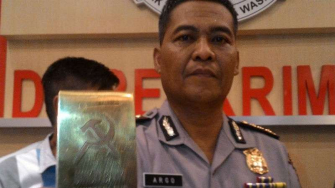 Emas palsu berbentuk batangan dengan logo palu arit dan sejumlah barang bukti yang diberikan Dimas Kanjeng kepada korbannya ditunjukkan polisi di Polda Jatim, Surabaya, pada Jumat, 30 September 2016.