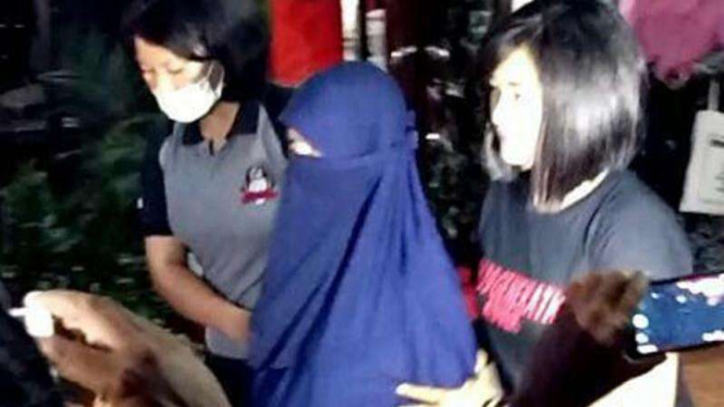 Tini Susanti, istri Ali Kalora (tengah).