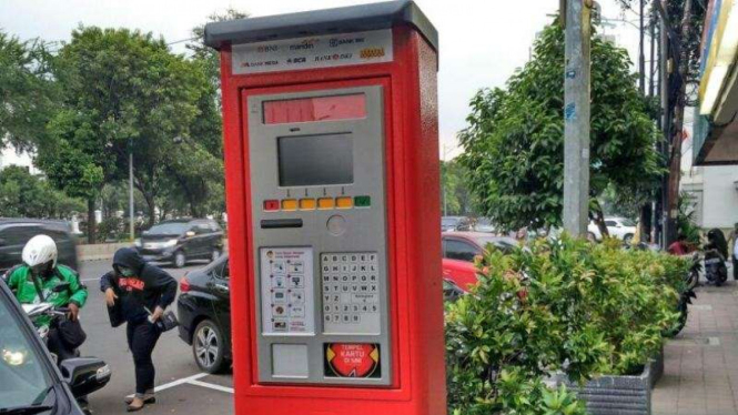 Mesin Terminal Parkir Elektronik di pinggir jalan.