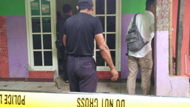 Petugas kepolisian membongkar lantai indekos mayat Sopyan yang disemen.