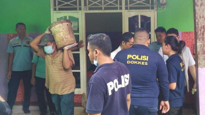 Petugas kepolisian gali lantai tempat Sopyan dikubur dan disemen.