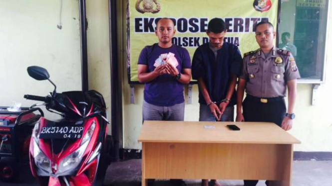 MRJ (tengah) tersangka pemerasan, dengan barang bukti uang dan sepeda motor