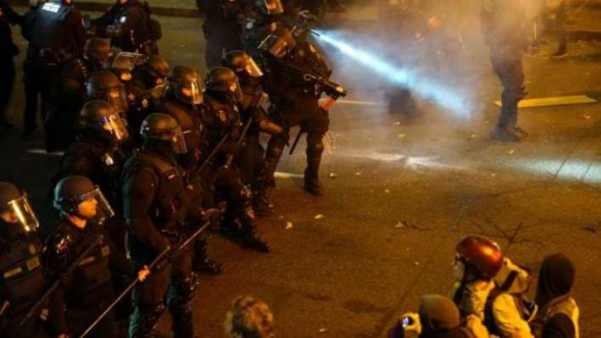 Polisi mengamankan demo menolak Donald Trump.