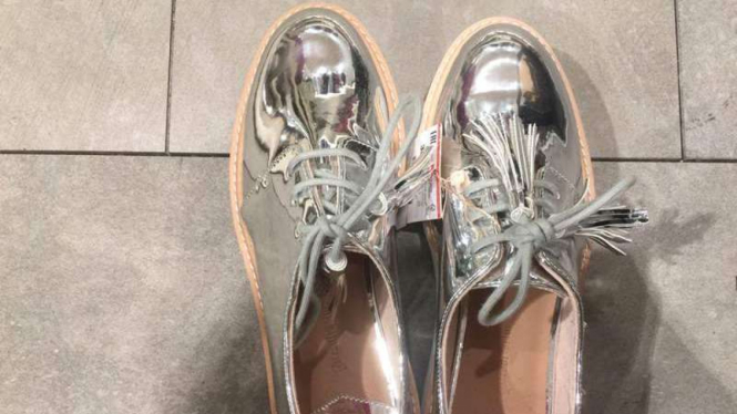 Sepatu warna perak.