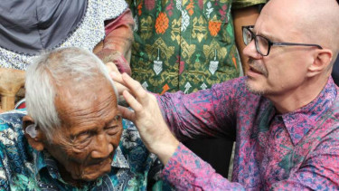 Saparman Dimejo alias Mbah Gotho (kiri), warga Sragen yang diklaim sebagai manusia tertua, diperiksa telinganya sebelum dipasangi alat bantu dengar di Solo pada Senin, 14 November 2016.