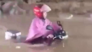 Seorang ibu nekat menerjang banjir.
