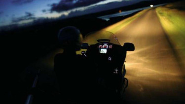 Mengendarai motor di malam hari.