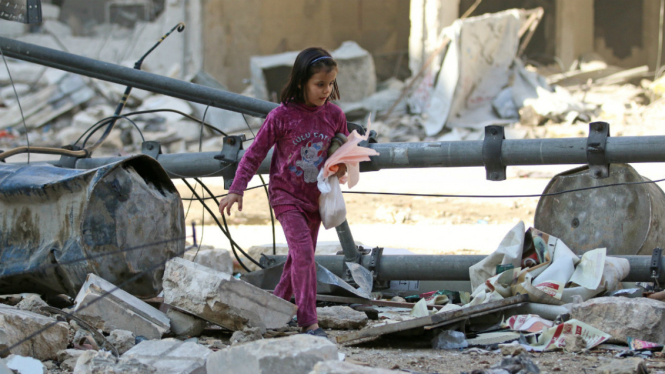 Seorang bocah berjalan di antara bangunan yang runtuh akibat serangan udara di Aleppo Suriah 17 November 2016. Menurut PBB, Aleppo telah menjadi kuburan massal. 