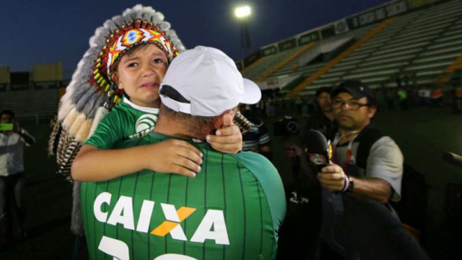 Seorang pendukung Chapecoense dan putranya yang berduka karena tragedi pesawat.