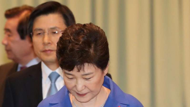 Presiden Korea Selatan, Park Geun-hye, (depan) dipecat dan posisinya diganti sementara oleh Perdana Menteri Hwang Kyo-ahn (belakang tengah).