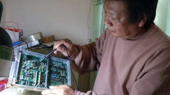 Hendry Basuki saat memperbaiki ECU mobil.