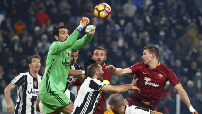 Kiper Juventus Gianluigi Buffon menepis bola dalam laga lawan AS Roma.