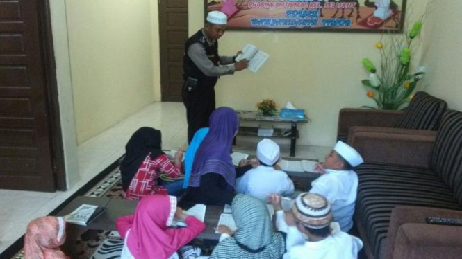 Bripka Fery mengajari anak-anak baca tulis Alquran.