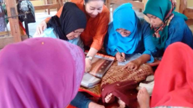 Ibu-ibu sedang membuat kain tenun