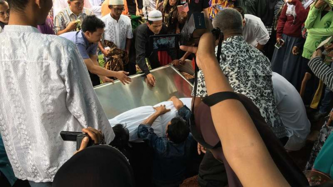 Jenazah Arum diturunkan ke liang lahat.