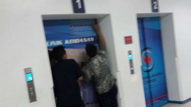 Petugas berusaha membuka lift saat dua remaja terjebak di dalamnya
