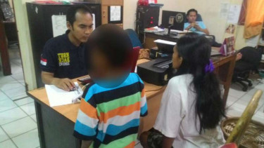 Seorang bocah korban pencabulan ditemani ibunya saat melapor kepada polisi di Palembang pada Jumat, 27 Januari 2017.
